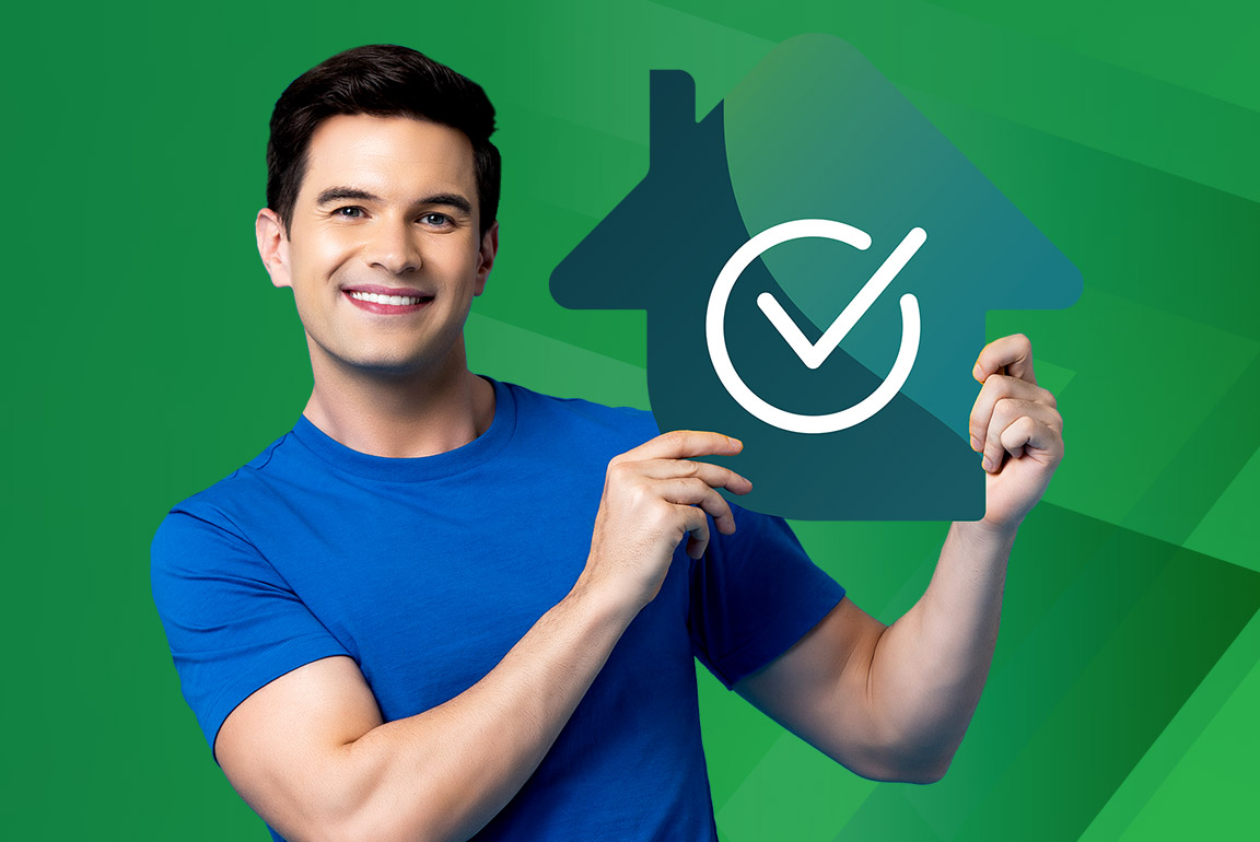 Smiling man holds a symbol of a house with a check mark