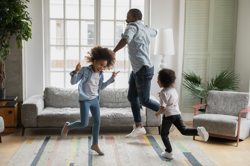 happy family dancing in living room