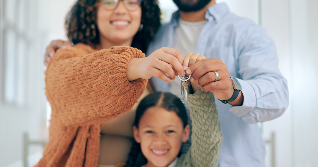 Smiling couple with child holding a key
