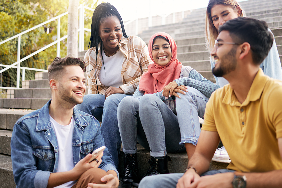 Smiling, diverse students gathered on campus steps