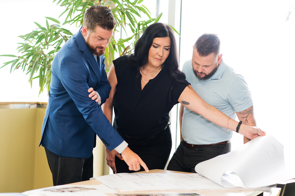 Qualico employees reviewing blueprints and plans for a new housing development project