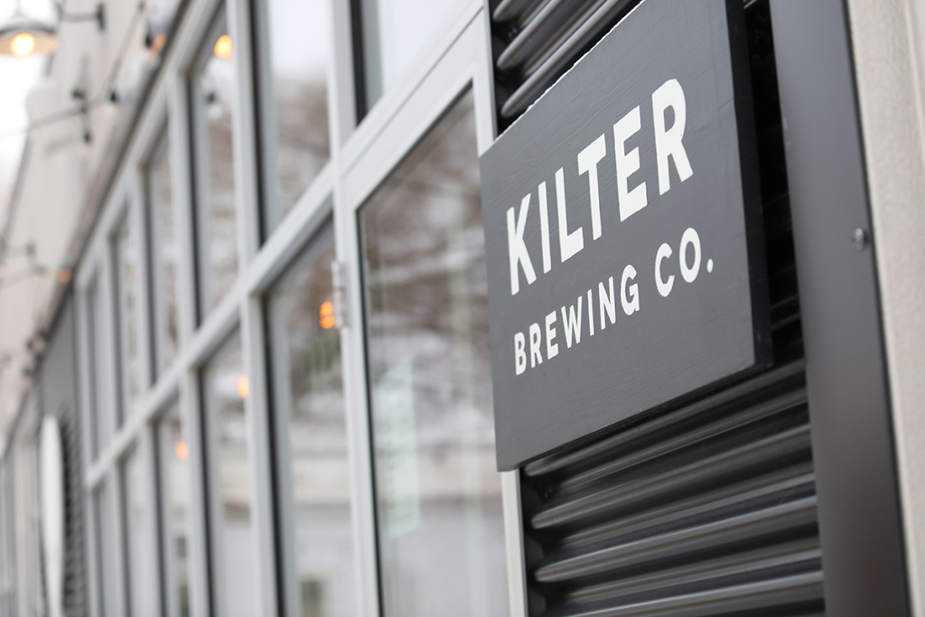 Exterior of Kilter Brewing Co, with a focus on their sign